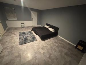 a bedroom with a black bed and a rug at Delightful Studio, 15 mins to Downtown Atlanta in Salem West