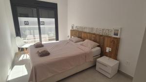 a bedroom with a bed with a wooden headboard at Casa Vitamin Sea in La Horadada