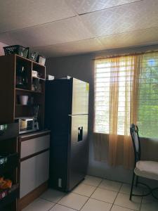 cocina con nevera negra y ventana en Swellhome, en La Libertad