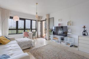 ein Wohnzimmer mit einem weißen Sofa und einem Fernseher in der Unterkunft Luxe Appartement Costa Blanca Altamira Las Ramblas in Orihuela