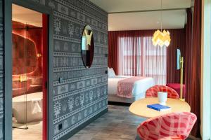a hotel room with a bed and a table and chairs at Nhow Lima in Lima