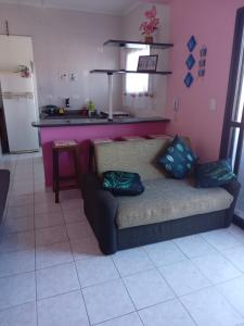 a living room with a couch and a kitchen at Edificio Residencial Vista Praia in Mongaguá