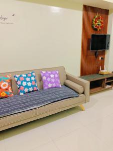 ein Sofa mit bunten Kissen im Wohnzimmer in der Unterkunft Cozynest Condotel Baguio unit 2 in Baguio City