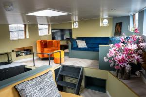 a living room with a couch and a table and flowers at Houseboat Reussi in Amsterdam