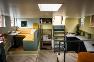 a tiny house with a loft bed and a desk at Houseboat Reussi in Amsterdam