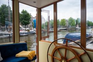 a boat with a window looking out on a river at Houseboat Reussi in Amsterdam