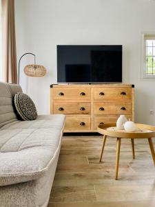 a living room with a couch and a tv and a table at Le jardin d'Opporak in Souraïde