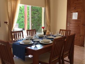 einem Esstisch mit Stühlen und einem blauen Tischtuch in der Unterkunft Katikies 19 in Pissouri