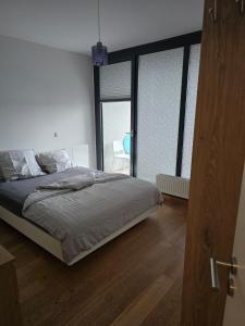 a bedroom with a bed and a large window at Bright, Modernized Apartment at Belval University in Esch-sur-Alzette