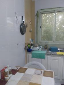 a kitchen with a sink and a toilet and a window at Location saisonnière un salon et deux chambres in Raʼs al Jabal +35 photos