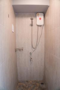 y baño alicatado con ducha. en Nature Home Hostel & Cafe, en Chiang Mai