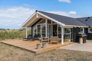 una casa con terrazza in legno e tetto di LN1816-Hjorring-Rodspaettevej-14 a Hjørring