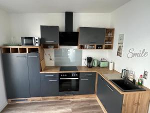 a kitchen with gray cabinets and a stove top oven at Sylt-Apartment in Hannover