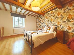 a bedroom with a bed with a tropical wallpaper at Le nid des Hirondelles avec borne de recharge in Villers-sur-le-Mont
