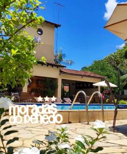 a villa with a swimming pool in front of a house at Hotel Moradas do Penedo in Penedo +11 photos