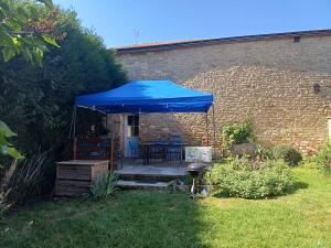 a blue umbrella on a patio in a yard at Le nid des Hirondelles avec borne de recharge in Villers-sur-le-Mont