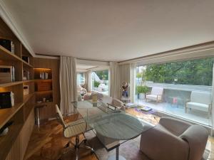 een woonkamer met een glazen tafel en een bank bij Residence L Heritage Tennyson in Mexico-Stad