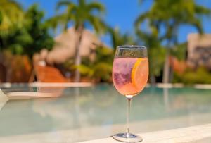 una copa de vino sentada en una mesa junto a una piscina en Stunning 6 Private Villas & PH /Wifi/AC/Pool/Gym., en Tulum