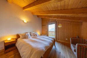 Un dormitorio con una cama grande en una habitación con ventana. en Chalet Chocolat - Great view, en Nendaz