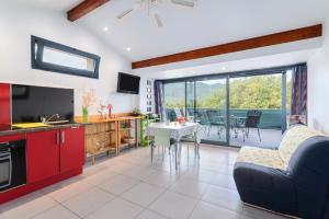 a kitchen and living room with a couch and a table at Gîte F2, Dans Un Coin De Paradis in Céret