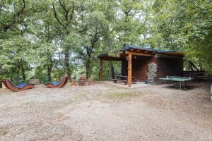 Un refugio para picnic con sillas y una mesa, y una mesa de picnic. en Gîte F2, Dans Un Coin De Paradis, en Céret
