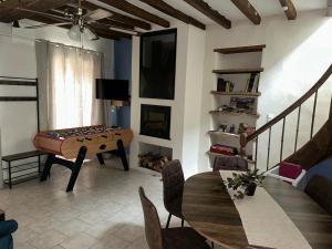 a living room with a ping pong table and a dining room at Gîte en Sarthe avec sauna et jacuzzi in Saint-Georges-du-Rosay