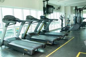 a gym with several tread machines in a room at Apartamento moderno e aconchegante com vista para a Esplanada in Brasília