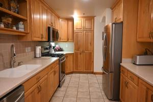una cucina con mobili in legno e un frigorifero in acciaio inossidabile di Swiss-charmed Mountain Retreat New Listing a Midway