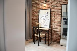 a brick wall with a sign and a chair at Apartament Loft Centrum in Częstochowa