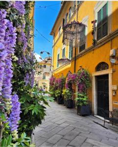 a street with flowers on the side of a building at Palazzo Lari Sarzana - Historic Boutique Rooms in Sarzana