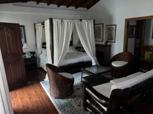 a bedroom with a bed and a couch and chairs at Casablanca Hotel Boutique Salamina in Salamina