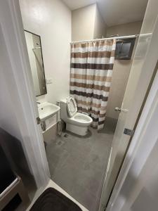 ein Badezimmer mit Toilette, Waschbecken und Spiegel in der Unterkunft WV Towers in Iloilo City