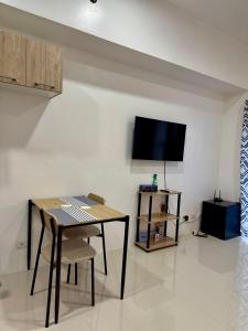 ein Esszimmer mit einem Tisch und einem Flachbildfernseher in der Unterkunft WV Towers in Iloilo City + 4 Fotos