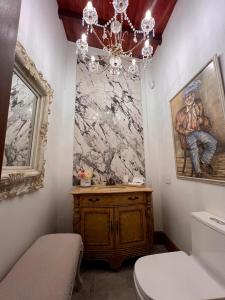 a bathroom with a painting on the wall and a chandelier at Casablanca Hotel Boutique Salamina in Salamina