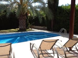 a group of chairs sitting next to a swimming pool at Katikies 19 in Pissouri