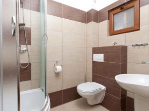 a bathroom with a toilet and a sink and a shower at Domki Marlin in Rewal +38 photos
