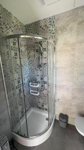 a shower with a glass door in a bathroom at Mały biały domek Wadowice SPA jacuzzi sauna Gorzen blisko Wadowic in Gorzeń Dolny +25 photos