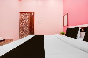a room with a black and white bed and a door at Hotel O S G H INN in Kakarmatha
