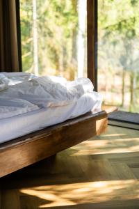 a bed sitting on a wooden platform next to a window at Lootvina Houses - Linnast välja, puu otsa! in Lootvina