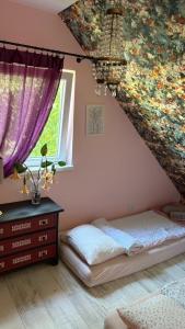 a bedroom with a bed and purple curtains at Mały biały domek Wadowice SPA jacuzzi sauna Gorzen blisko Wadowic in Gorzeń Dolny