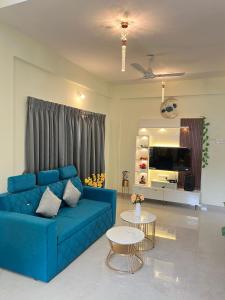 a living room with a blue couch and a table at Tej Villa, 3 Bhk villa at pushpam sanskruti,Karjat in Dhamni
