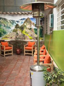 Una habitación con sillas y una pared con un cuadro. en Hostel Tupac Yupanqui House, en Cusco