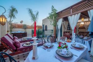 - une table avec des assiettes et des bougies sur la terrasse dans l'établissement Riad Le Nid De Fatima, à Marrakech