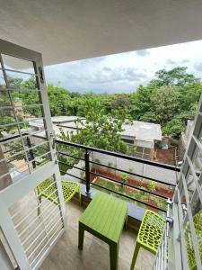a balcony with a green table and chairs at Tej Villa, 3 Bhk villa at pushpam sanskruti,Karjat in Dhamni