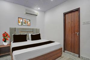 a bedroom with a bed and a wooden door at HOTEL O SMALL TOWN in New Delhi