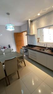 a kitchen with a table and chairs and a sink at Kingdom Of Eagles Bedroom in Londrina +7 photos