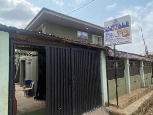 un edificio con una puerta y un cartel delante en Capital E Hotel, en Ibadán