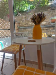 a table and chairs with a vase on top of it at Samos Cozy Apartment II in Samos +1 photo