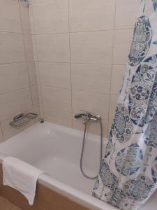 a bathroom with a bath tub with a shower curtain at Samos Cozy Apartment II in Samos