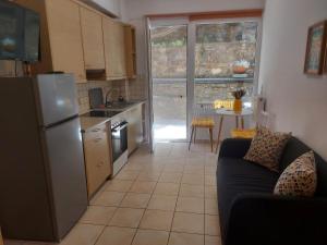 a kitchen with a refrigerator and a couch in a room at Samos Cozy Apartment II in Samos